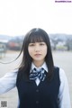 A young woman in a school uniform posing for a picture.