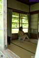 A woman sitting on the floor in front of a window.