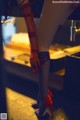 A woman in red stockings and high heels standing in a room.