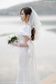 A woman in a wedding dress holding a bouquet of flowers.