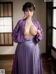 A woman in a purple kimono posing for the camera.