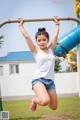 A young woman is hanging upside down on a monkey bars.