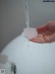 A person is washing their hands under a faucet.