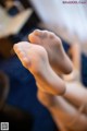 A close up of a person's bare feet on a bed.