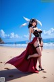 A woman in a bunny costume is standing on the beach.